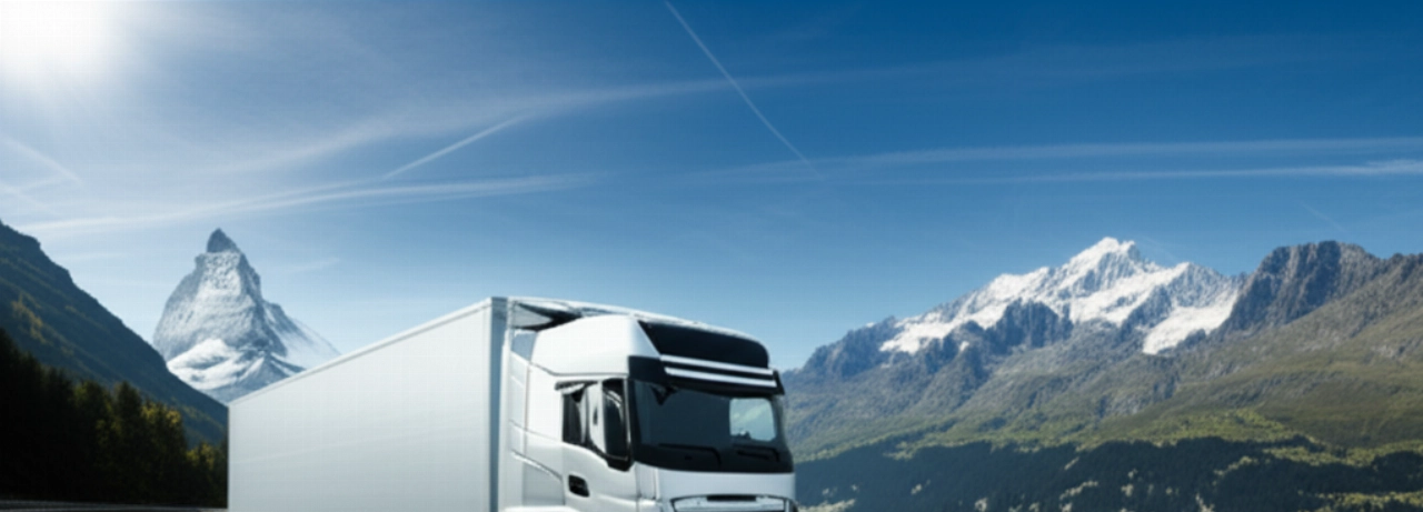 Moderno camión de mudanzas viajando por una autopista panorámica con los Alpes suizos.